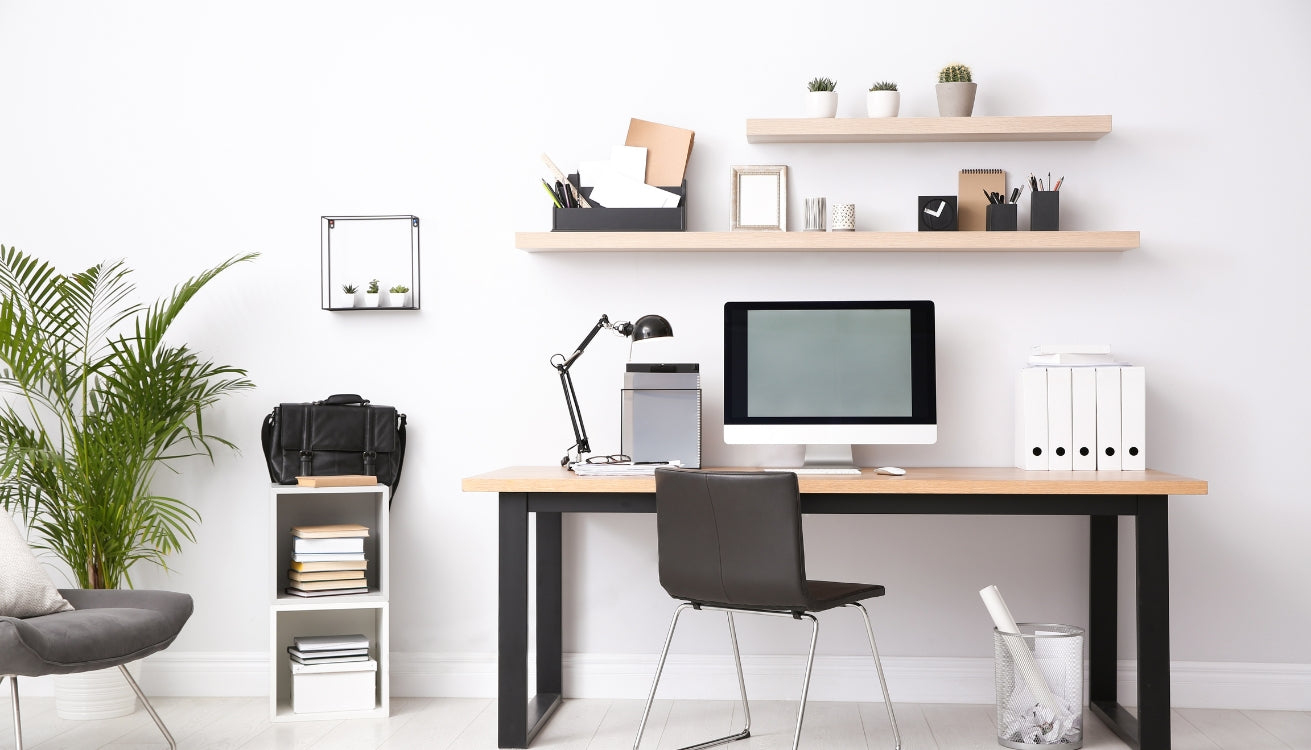Image of a modern home office with a wood-top desk, black legs, floating shelves, and neatly arranged supplies for efficient organization.