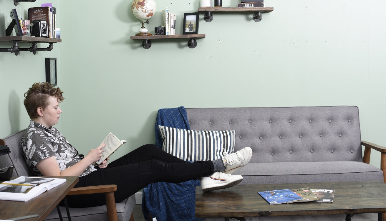 An industrial styled living room with pipe shelves and a pipe coffee table.