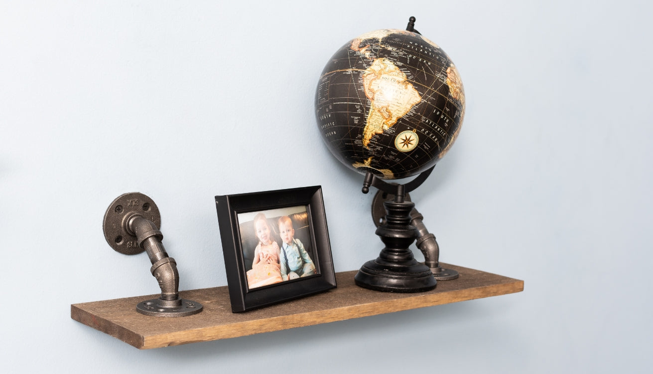 Image of a pipe shelf  with a globe and a picture frame.