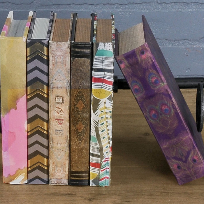 Stylish pipe bookends with a black finish holding colorful books upright, adding an industrial touch to the decor.